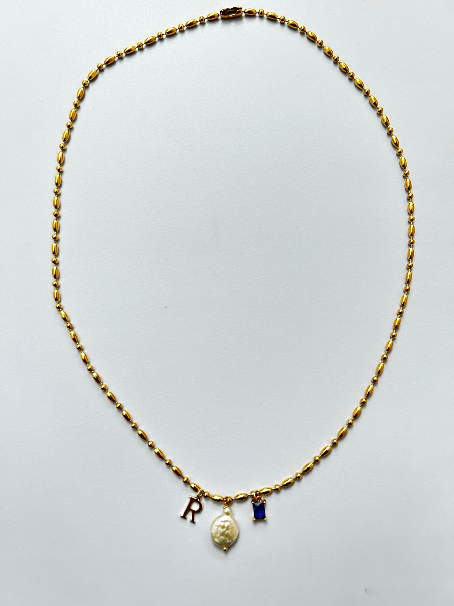 Collar dorado con perla, inicial y joya